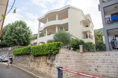 a white building on a wall next to a street at Guesthouse Dapcevic in Budva