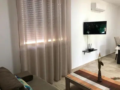 a living room with a couch and a large window at Stanovic Bungalow in Ulcinj