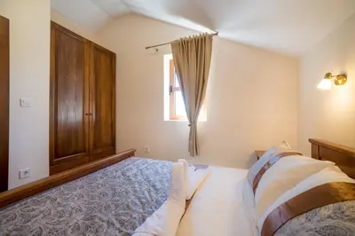 a bedroom with a bed and a wooden cabinet at Villa Old Castle Apartments in Kotor