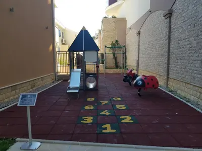 a playground with two play items on a tile floor at Apartment Anatolia Pekovic in Becici