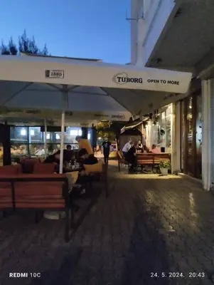 a restaurant with people sitting at tables under an umbrella at Apartments Natali in Bar