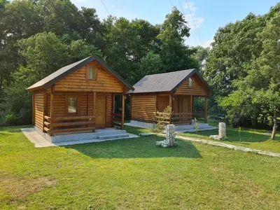 a log cabin in a yard with a grass yard at Little Paradise in Virpazar