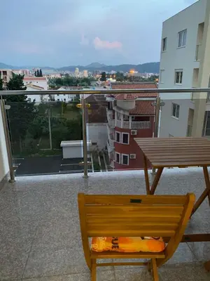 a wooden bench sitting on top of a balcony at Luda kuća in Bar