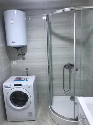 a bathroom with a washing machine and a shower at Luda kuća in Bar
