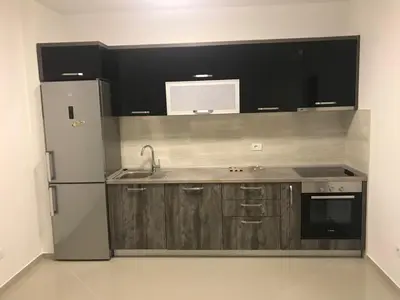 a kitchen with wooden cabinets and a stainless steel refrigerator at Luda kuća in Bar