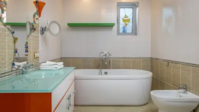 a bathroom with a tub and a sink and a toilet at Villa Aurora in Petrovac na Moru