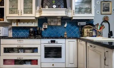 a kitchen with white cabinets and a blue wall at Villa Aurora in Petrovac na Moru