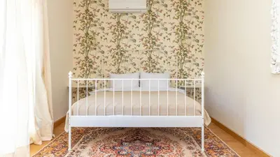 a white crib in a room with a floral wallpaper at Villa Aurora in Petrovac na Moru