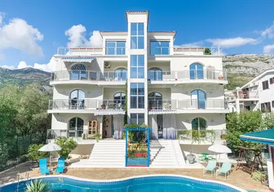 a large white building with a pool in front of it at Villa Aurora in Petrovac na Moru