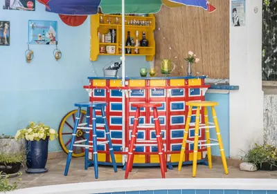 a colorful bar with stools next to a pool at Villa Aurora in Petrovac na Moru