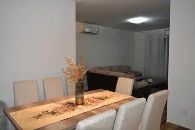 a dining room table with chairs and a vase on it at Apartments Sea View in Kotor