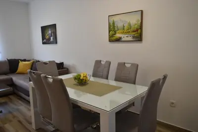 a dining room with a white table and chairs at Apartments Sea View in Kotor