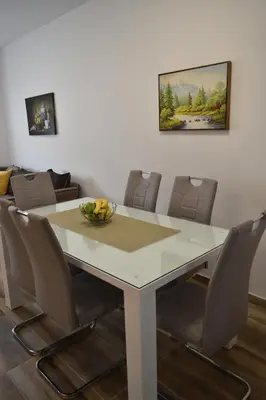 a dining room with a white table and chairs at Apartments Sea View in Kotor
