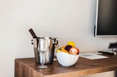 a bowl of fruit and a wine glass on a desk at Sunset Hotel in Dobra Voda