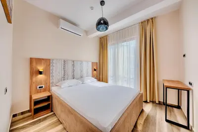 a bedroom with a large bed and a window at Sunset Hotel in Dobra Voda