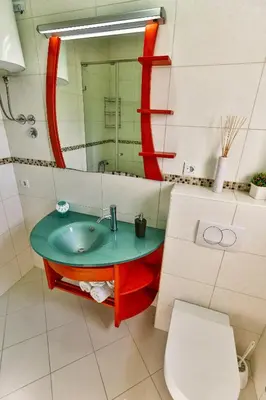 a bathroom with a sink and a mirror and a toilet at Zelen LUX in Sutomore