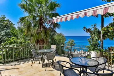 a patio with tables and chairs and the ocean at Zelen LUX in Sutomore