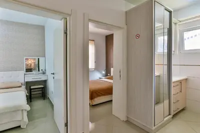 a bedroom with a bed and a desk and a mirror at Zelen LUX in Sutomore