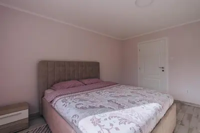 a bedroom with a large bed with pink pillows at Apartment Majstorina in Virpazar