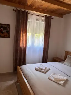 a bedroom with a bed with two towels on it at Sunlight Cottage Maya in Virpazar