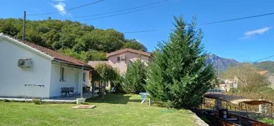 a small yard with a house and a tree at Sunlight Cottage Maya in Virpazar