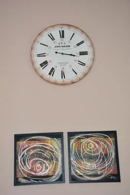 a clock hanging on a wall next to two pictures at Vila Pelinovo in Kotor