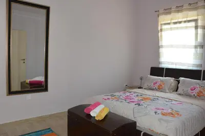a bedroom with a bed with a mirror and a table at Vila Pelinovo in Kotor