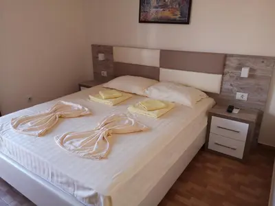 a bedroom with a white bed with two towels on it at Rooms Ibrocevic in Ulcinj