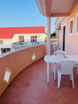 a patio with a white table and chairs on a balcony at Rooms Ibrocevic in Ulcinj