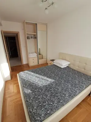 a bedroom with a large bed and a mirror at Apartman Verica in Rafailovici