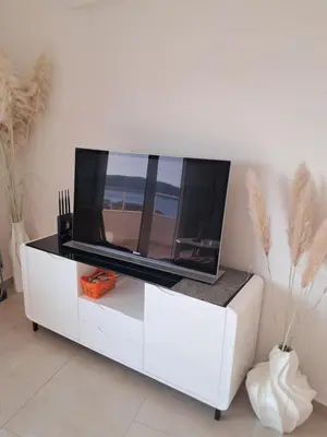 a white entertainment center with a flat screen tv on it at Apartman Verica in Rafailovici