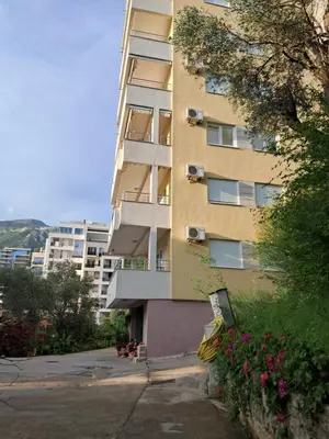 a tall apartment building with flowers in front of it at Apartman Verica in Rafailovici