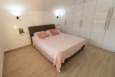 a bedroom with a bed and white cabinets at Honey Farm House in Virpazar