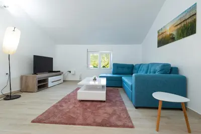 a living room with a blue couch and a table at Honey Farm House in Virpazar