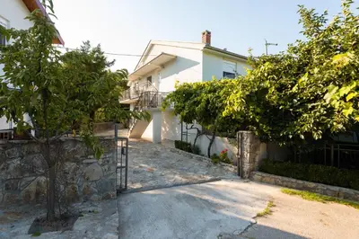 a white house with a fence and trees at Honey Farm House in Virpazar