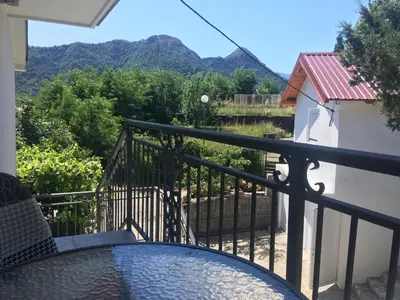 a balcony with a table and a view of mountains at Honey Farm House in Virpazar
