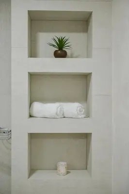 a bathroom shelf with towels and a plant on it at Brand New Apartments - free parking in Sveti Stefan