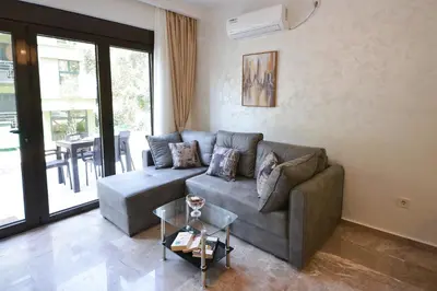 a living room with a couch and a table at Brand New Apartments - free parking in Sveti Stefan