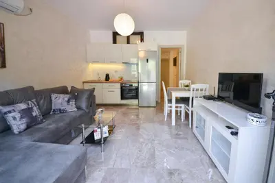 a living room with a couch and a kitchen at Brand New Apartments - free parking in Sveti Stefan