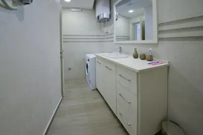 a bathroom with a sink and a washing machine at Brand New Apartments - free parking in Sveti Stefan