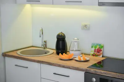 a kitchen counter with a sink and a cutting board with oranges at Brand New Apartments - free parking in Sveti Stefan