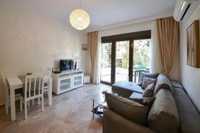 a living room with a couch and a table at Brand New Apartments - free parking in Sveti Stefan