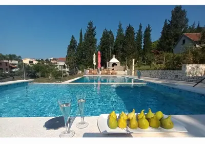 a pool with a table with glasses and pears on it at Villa Katarina in Tivat