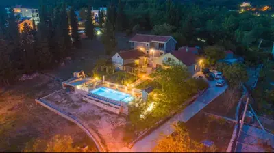 an overhead view of a house with a swimming pool at night at Villa Katarina in Tivat