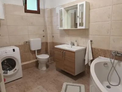a bathroom with a toilet sink and a washing machine at Villa Katarina in Tivat