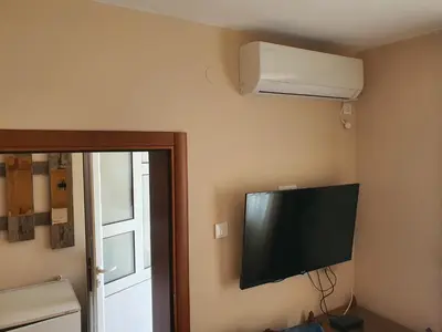 a flat screen tv on the corner of a room at Kod Nade in Petrovac na Moru