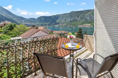 a balcony with a table with a vase of flowers on it at Antonella in Kotor