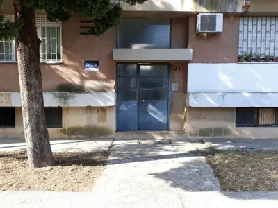 a door of a building with a tree in front at Stan u centru in Podgorica