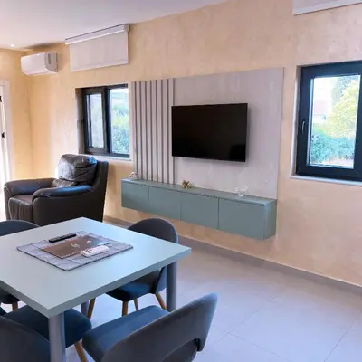 a living room with a tv and a table and chairs at Apartments Aerodrom in Podgorica