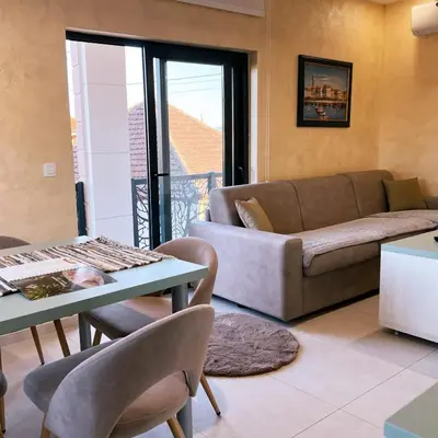 a living room with a couch and a table and chairs at Apartments Aerodrom in Podgorica